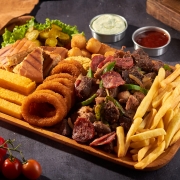 Porções: 82-Carne na Tábua Grande - Porção (Ingredientes: Carne, Coração, Frango, Calabresa, Bolinho de aipim, Pãozinho, Polenta Frita, Batata Frita, Farofa, Alface, Tomate, Pepino e Cebola,anel de cebola,pimentão)