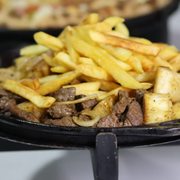 Porções: Filé à Kabana - Grande (Ingredientes: Abacaxi, Bacon, Cebola, Filé Mignon, Fritas, Mandioca, Molho Verde, Mussarela, Ovo de Codorna, Tomate, Torresmo)