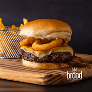 burger brood: Brood Onion Rings - Hambúrguer (Ingredientes: Pão Tipo Brioche, Molho Brood, Bacon, Hambúrguer Bovino, Queijo Muçarela, Cheddar Cremoso, Onion Rings, Maionese Verde, * Acompanha Porção de Batatas Fritas!)