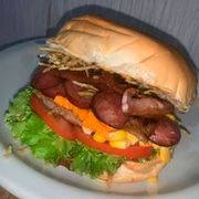 Hambúrguer: X-Calabacon - Hambúrguer (Ingredientes: Alface, Bacon, Batata Palha, Calabresa, Catupiry, Cheddar, Hambúrguer Aurora, Milho, Molho Especial, Pão, Presunto, Queijo, Tomate)