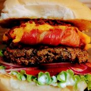 Burguer Gourmet: Take Bacon Gourmet - Hambúrguer (Ingredientes: Pão de Brioche Tostado na Manteiga, Blend Bovino de 150g, Anel de Cebola Envolto em Bacon, Creme de Cheddar (Polenguinho), Farofa de Bacon, Alface, Tomate, Cebola Roxa, Maionese Especial)