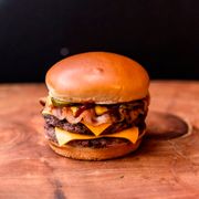 Hambúrguer: Cheeseburguer - Cheeseburger (Ingredientes:  Cebola,  Duas fatias de picles,  Duas fatias de queijo,  Hamburguer 100% bovino de 160g grelhado na brasa,  Ketchup,  Mostarda, Pão brioche)