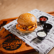 Hambúrguer na Brasa: Chegada do Cheddar - Hambúrguer (Ingredientes:  Bacon em cubos,  Doritos,  Queijo cheddar, Cheddar cremoso, Hambúrguer angus 160g na brasa, Maionese da casa, Pão brioche selado no fogo)