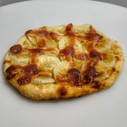 Esfihas Premium: Esfiha de Banana Nevada - Massa, mussarela, banana, chocolate branco, canela e açúcar.