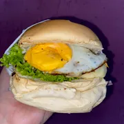Hambúrguer: X-EGG - Hambúrguer (Ingredientes: Alface, Batata Palha, Catupiry, Cheddar, Hambúrguer Aurora, Milho, Molho Especial, Ovo, Pão, Presunto, Queijo, Tomate)