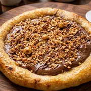 Edicao Limitada Mes das Mulheres: Esf Ferreiro choco - Esfiha aberta de chocolate ao leite com amendoas trituradas deliciosamente crocante (fina camada de mussarela na base)