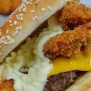 Burguer Artesanal: Copacabana - Burguer Artesanal (Ingredientes: Pão Brioche, Maionese da Casa, Burguer de 150gr, Queijo Prato, Cebola Roxa, Catupiry, Bacon Empanado, Picles)