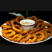Aperitivos na Brasa: Mini Burgers sobre Onion Rings - 8 unidades de suculentos mini burgers servidos sobre anéis de cebola crocantes. Acompanha maionese da casa.
