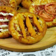 Salgadas: Esfirra Bacon com cheddar - Mussarela, bacon, cheddar e orégano