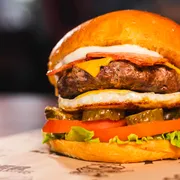 Hambúrguer: Americano - Hambúrguer (Ingredientes: Pão brioche com gergelim, Hambúrguer Angus 160g, Queijo Cheddar fatiado, Catupiry, Bacon em tiras, Ovo, Alface Americana, Tomate, Picles)