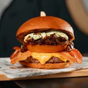 Burgers: Brooklin - Burger (Ingredientes: Pão Brioche, Burger 160g, Cebola Caramelizada, Tomate chapeado, Bacon, American Cheese Cheddar, Maionese Verde)