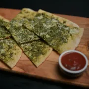 Crostine: Crostine Pesto - Massa romana crocante com pesto genovese e parmesão. Leve, aromática e cheia de personalidade.