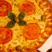 Tradicionais: 16- Marguerita - Pizza Grande (Ingredientes: Molho de Tomate,  Mussarela,  Tomate em rodelas,  Manjericão fresco,  Manjericão seco,  Azeitonas)