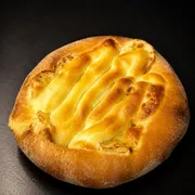 Doces: Esfiha Banana Nevada - Massa de esfiha com fubá, queijo mussarela, banana e chocolate branco flambado.