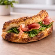 Panuozzo: Panuozzo Mediterrâneo - Nossa massa de pizza de longa fermentação na versão sanduíche. Leve, artesanal e assada no ponto perfeito, recebe Parma, ricota cremosa, geleia de figo, rúcula fresca e finalização com molho pesto, criando uma experiência equilibrada entre intensidade, frescor e elegância.