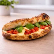 Panuozzo: Panuozzo Caprese - Massa de pizza de longa fermentação no formato de sanduíche. Leve, artesanal e assada no ponto perfeito, recebe mussarela de búfala, mussarela, tomate fresco e manjericão, entregando uma combinação delicada, equilibrada e atemporal.