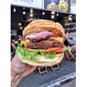 Hambúrguer: Da Casa - Hambúrguer (Ingredientes: Alface Americana, Bacon em tiras, Cebola Roxa, Hambúrguer Angus 160g, Maionese Especial Caseira, Pão de Hambúrguer tipo Brioche C/ Gergelim, Queijo Cheddar fatiado, Tomate)