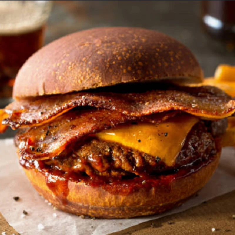 Lanches Tradicionais: X-bacon - Lanches Tradicionais (Ingredientes: Alface, Bacon crocante, Cebola, Hambúrguer 150g, Molho barbecue, Pão brioche, Queijo cheddar, Tomate)