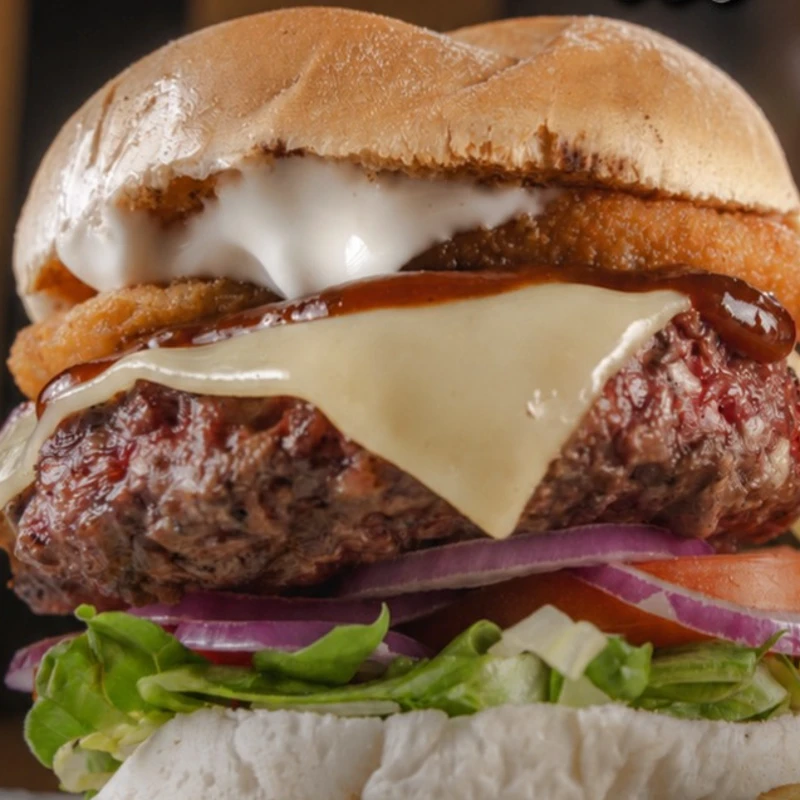 Hambúrguer: Prime BBQ Onion Rings - Hambúrguer (Ingredientes: 1 hambúrguer bovino, Alface Americana, Cebola Onion Rings, Cebola Roxa, Maionese, Molho Barbecue, Pão, Tomate)