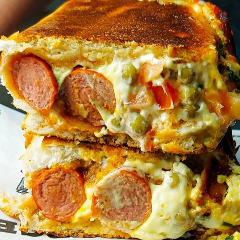 Hot Dog: Tradicional Duplo - Hot Dog (Ingredientes: Duas Salsichas Defumadas, Ervilha, Ketchup, Maionese, Molho Bolonhesa, Mostarda, Queijo Mussarela, Tempero Verde, Tomate)