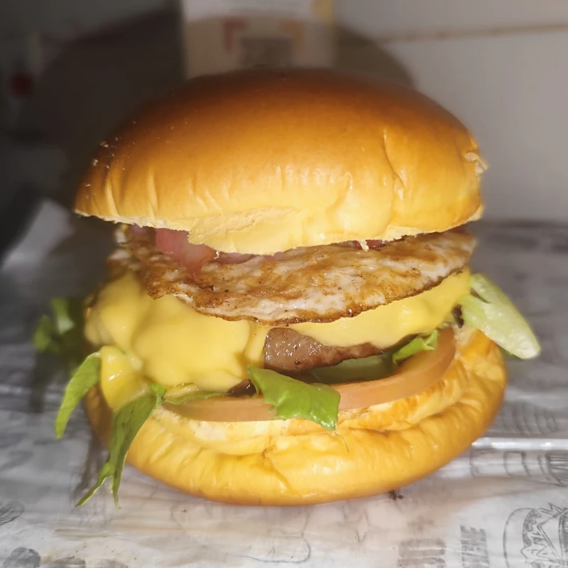Lanches artesanais: Egg e bacon - Lanches artesanais (Ingredientes: Bacon, Cebola, Hamburguer artesanal, Ovo, Pão brioche, Queijo prato, Salada)